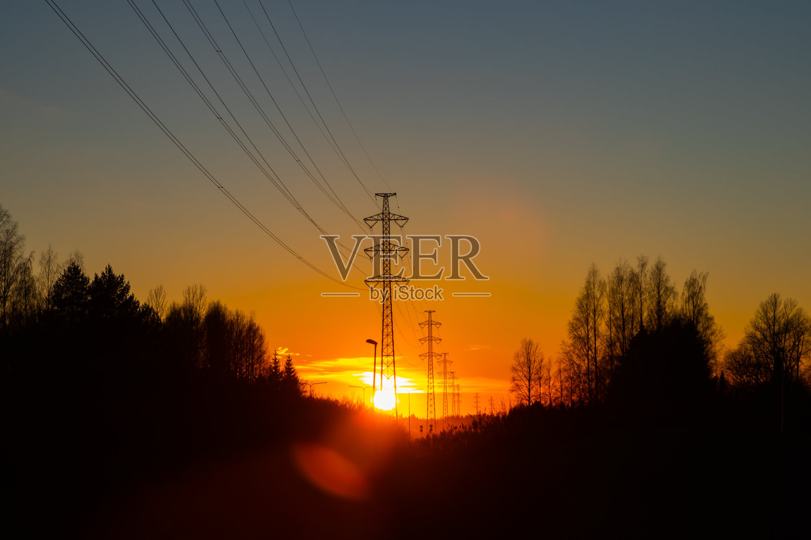 高压电塔映衬着美丽的夕阳照片摄影图片
