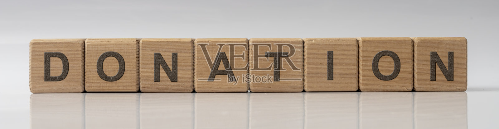 捐献字木方在白色灰色光泽的背景反射照片摄影图片