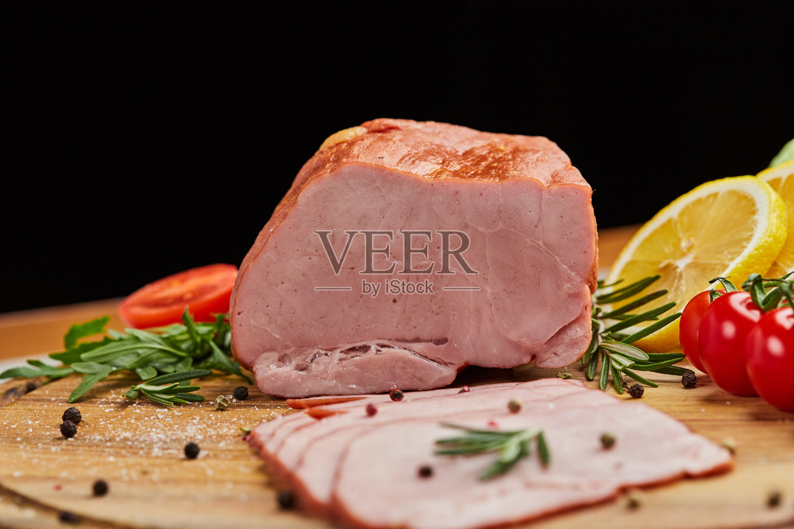 切成薄片的火腿与香料，生菜，鳄梨和西红柿在木砧板上。老肉板。新鲜火腿照片摄影图片