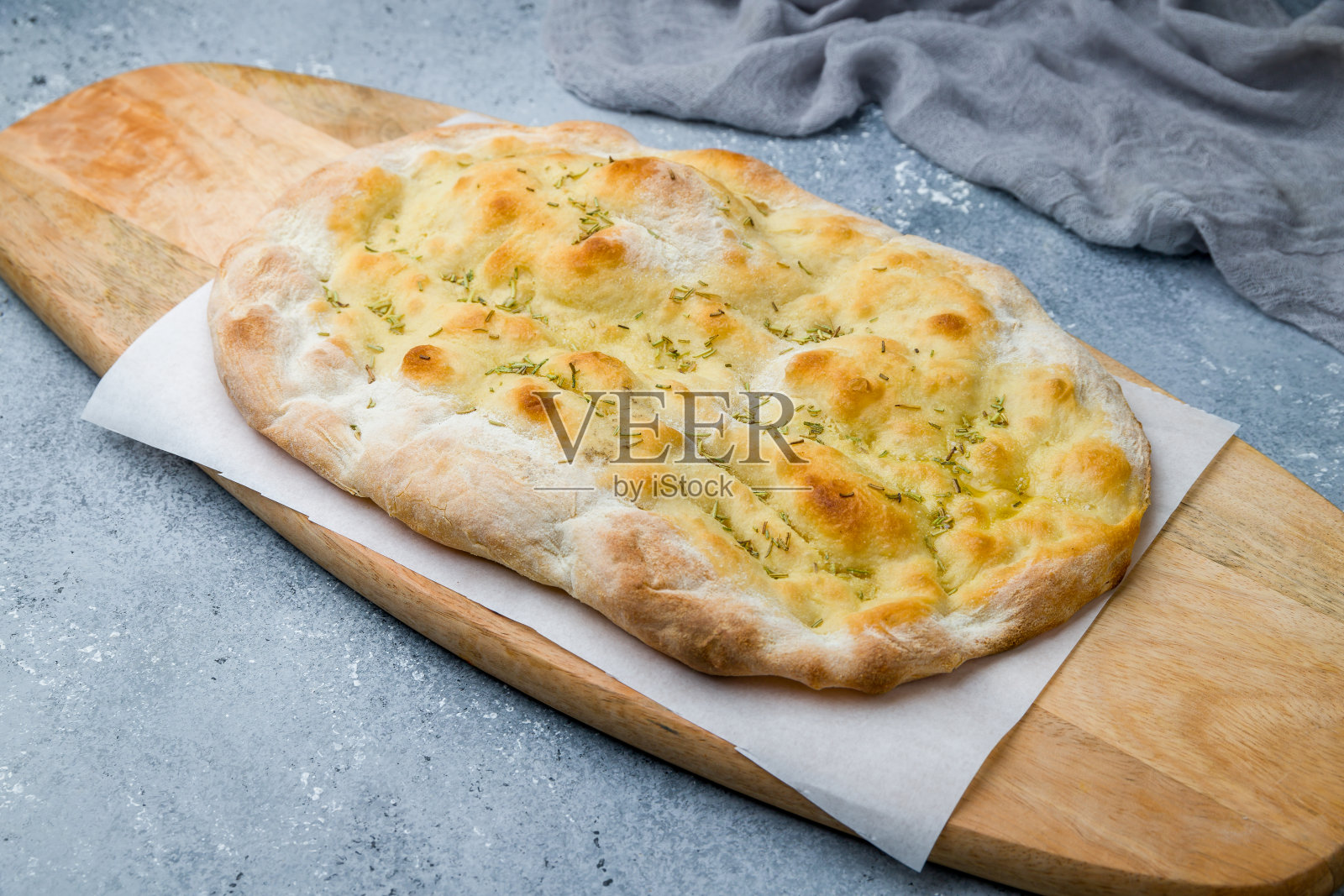 灰桌子上放着迷迭香佛卡夏面包照片摄影图片