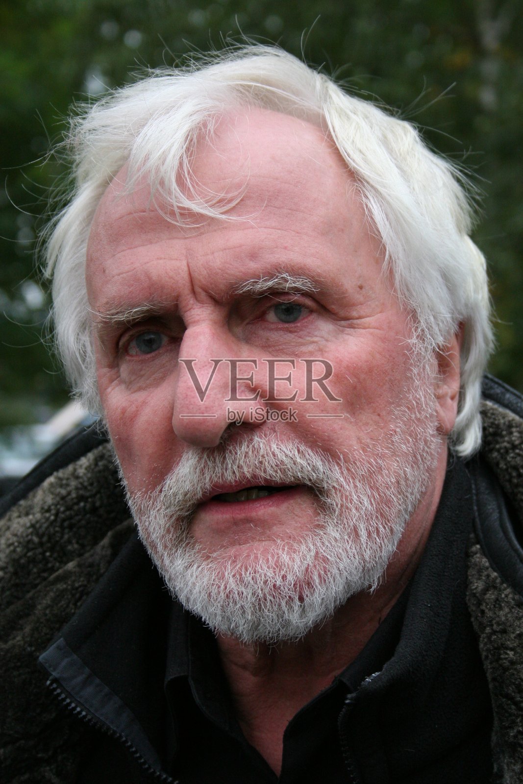 近距离肖像的白胡子高级与长黑色皮衣站在外面的公园照片摄影图片