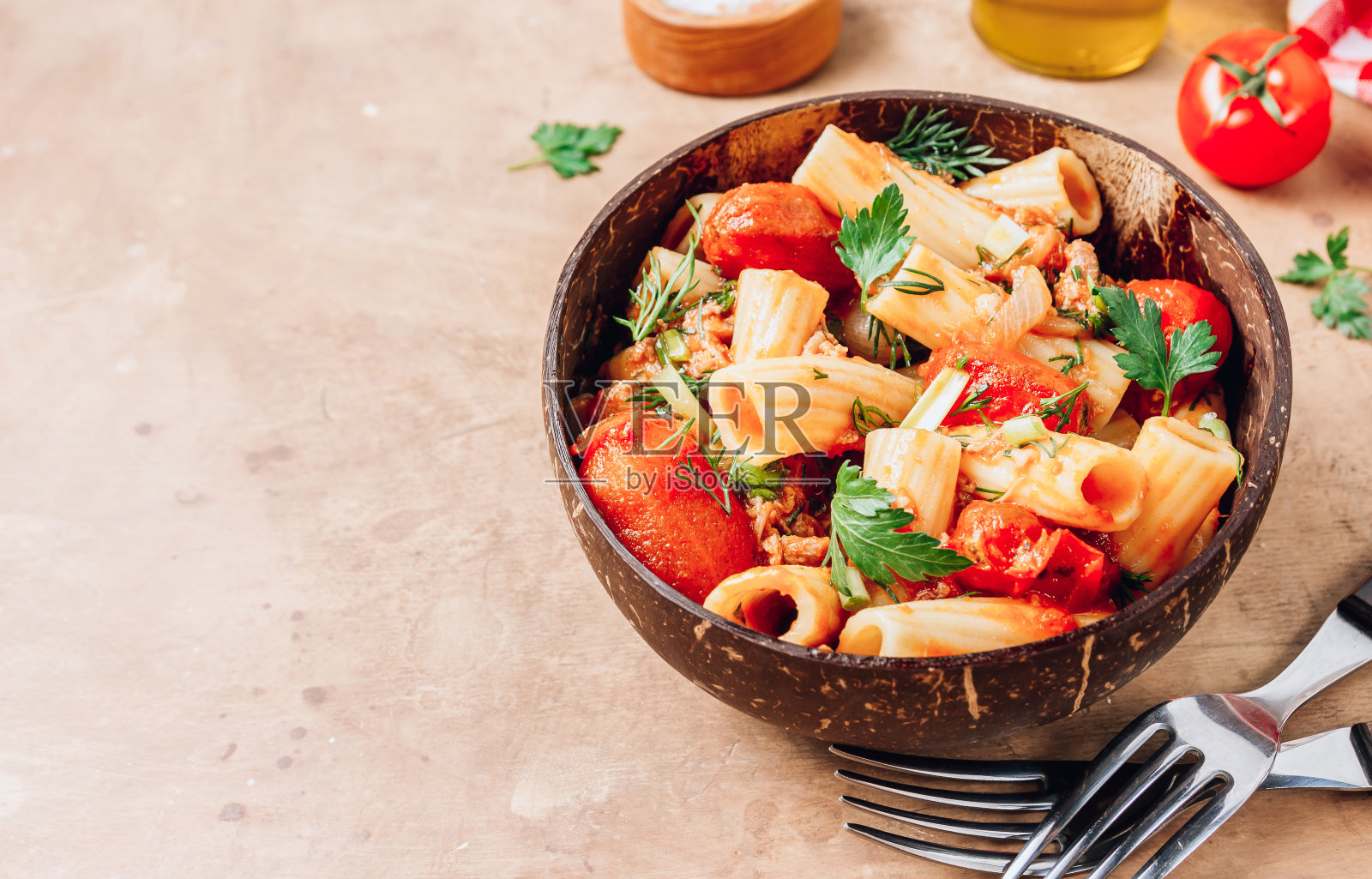 米色背景，椰碗里的意大利面皮，肉末，番茄酱和西红柿照片摄影图片