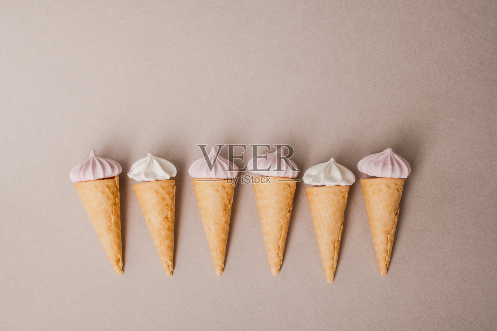 粉彩背景上点缀着彩色棉花糖的小脆华夫饼冰淇淋杯照片摄影图片