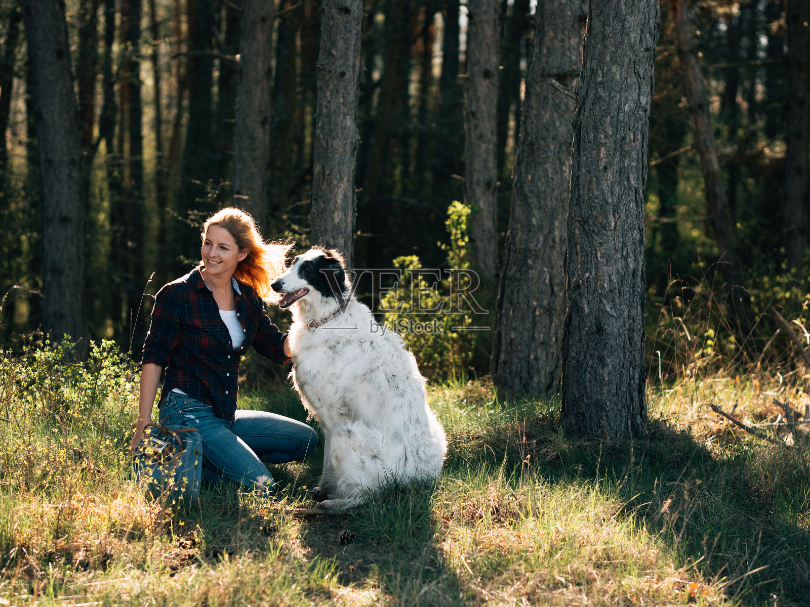 一个女人带着她的狗在森林里旅行照片摄影图片