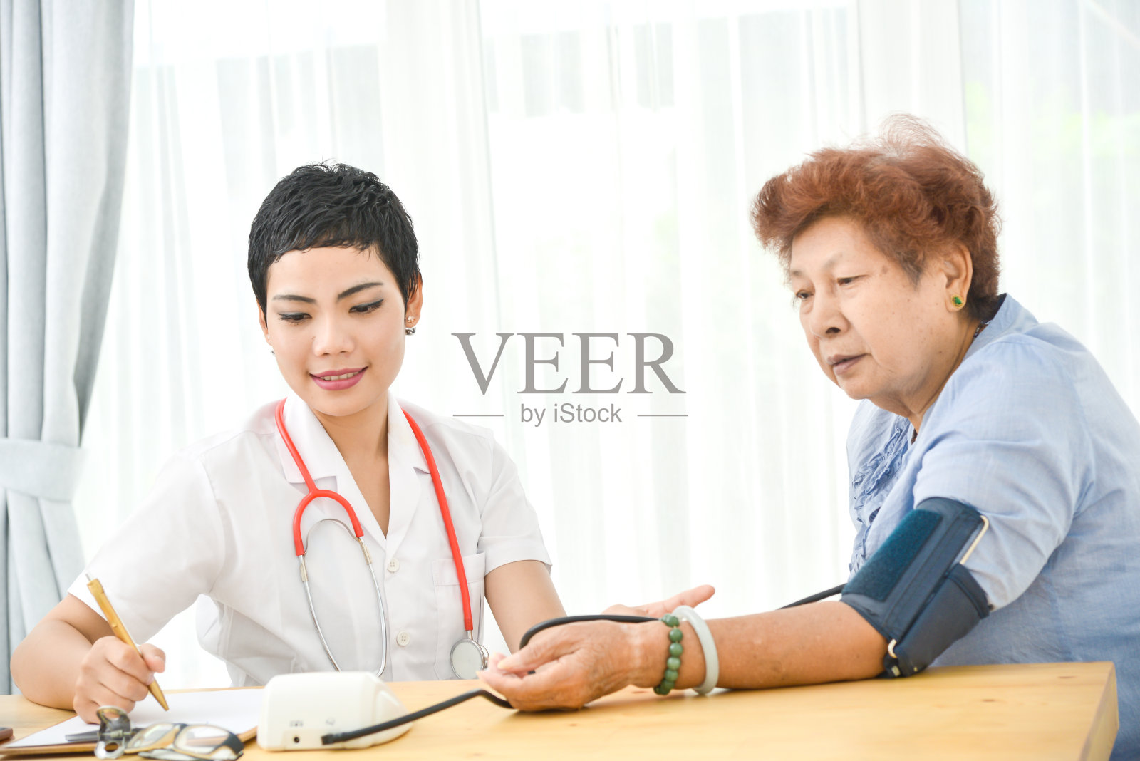 亚洲医生检查她的病人女性在办公室。照片摄影图片