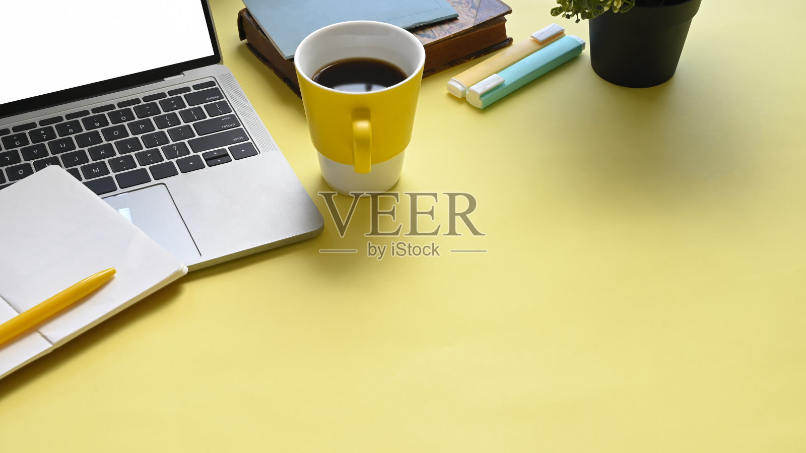 俯视图图像丰富多彩的工作场所，充满文件，咖啡杯，笔记本，钢笔，马克笔和电脑笔记本与白色空屏幕。照片摄影图片