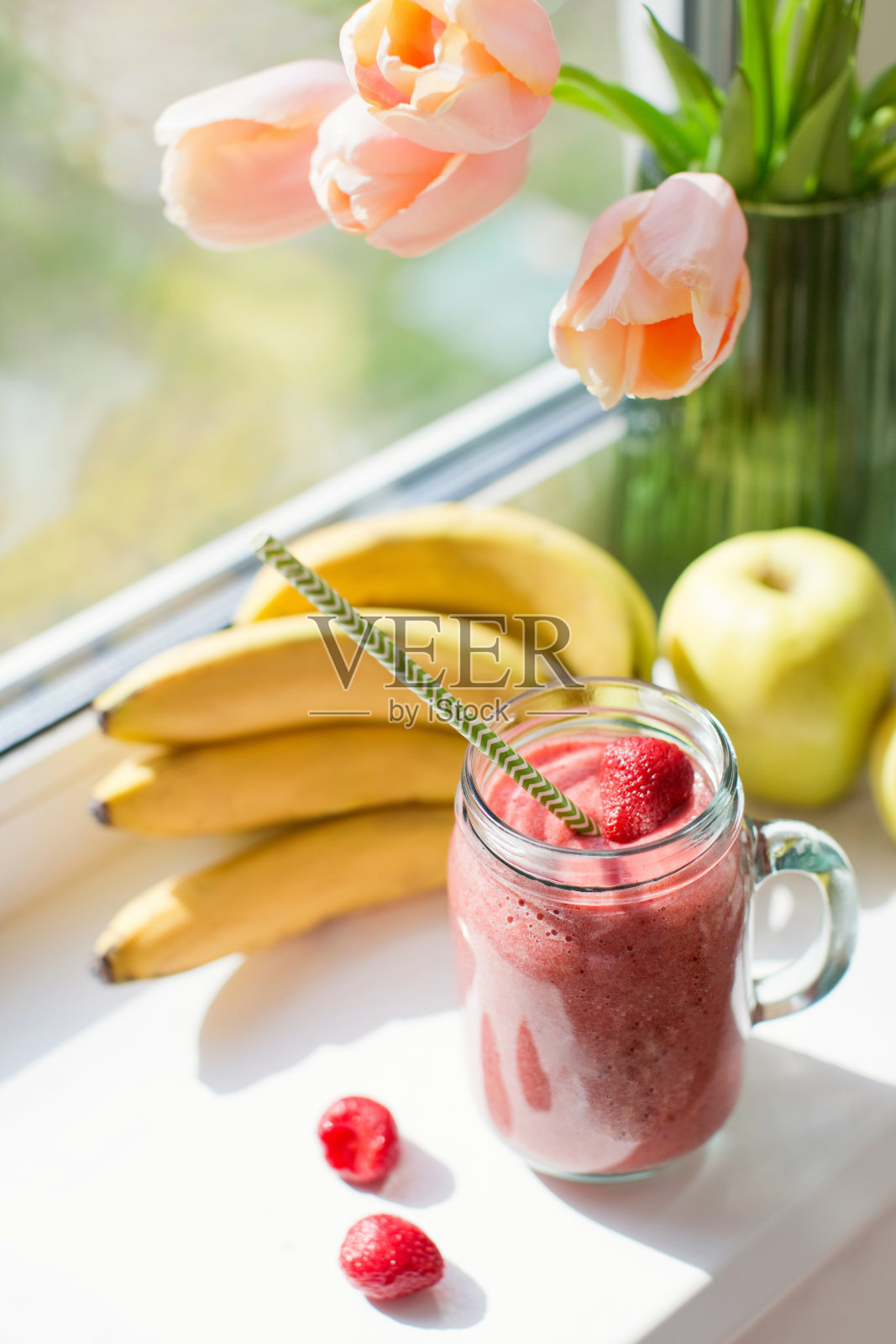 健康饮食奶昔，草莓，香蕉和苹果在玻璃玻璃瓶。照片摄影图片