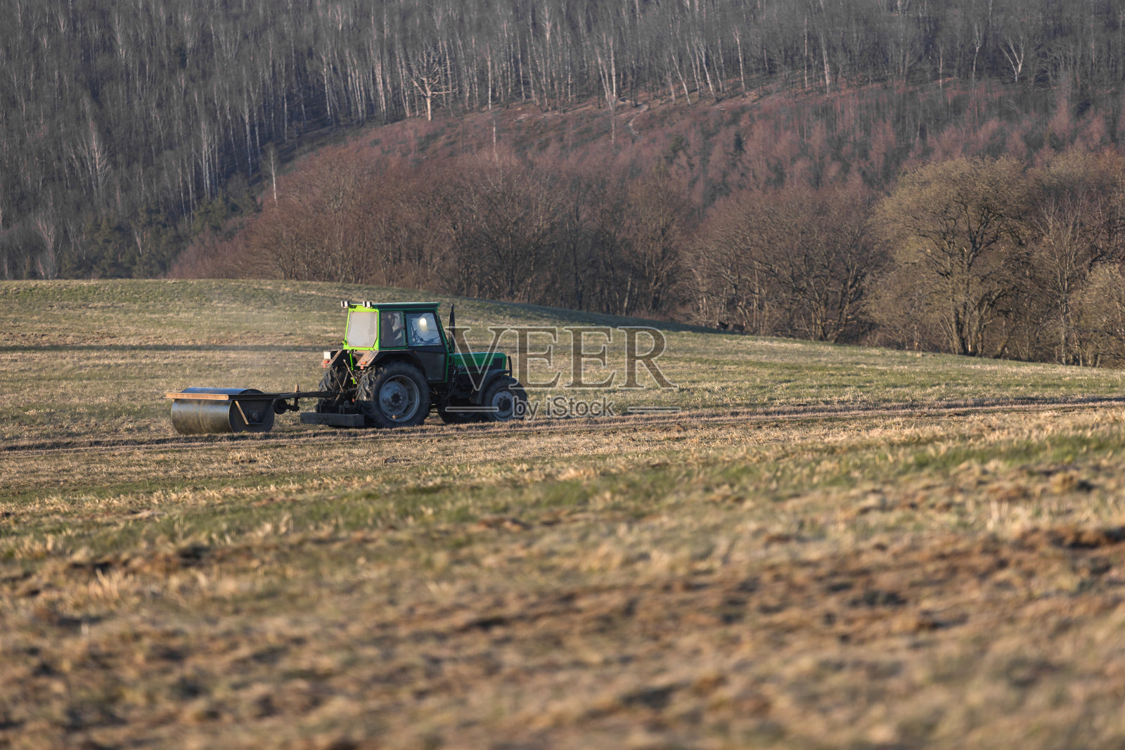 傍晚，拖拉机在草地上开着照片摄影图片