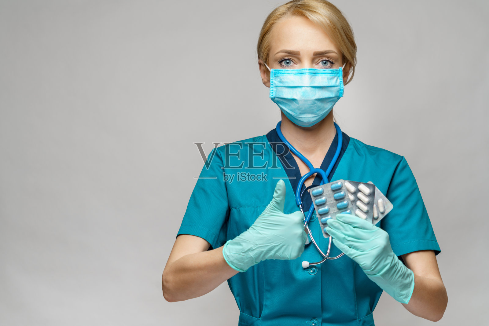 戴着防护口罩和乳胶手套的女医生拿着药丸照片摄影图片