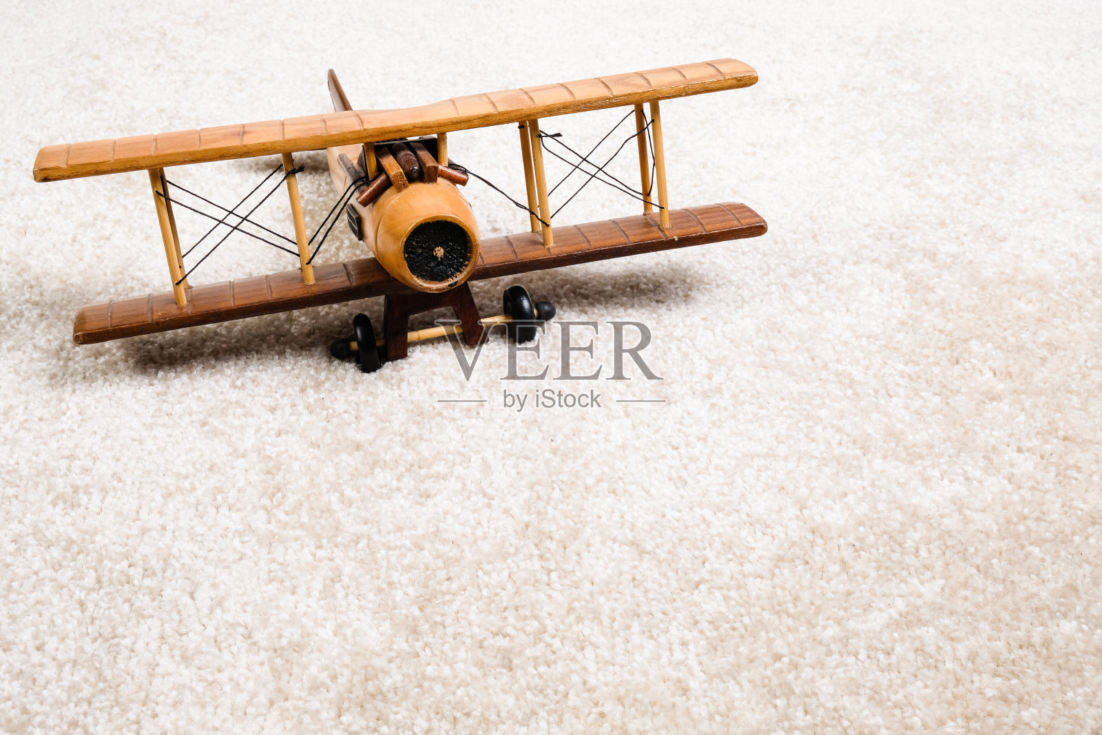 白色地毯上的木质飞机照片摄影图片