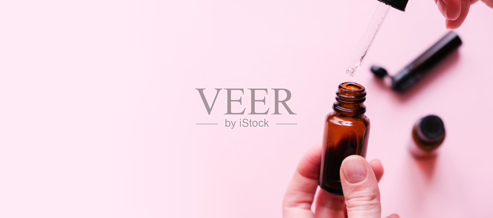 在其他药物的背景下，从玻璃滴管中掉落的精油照片摄影图片