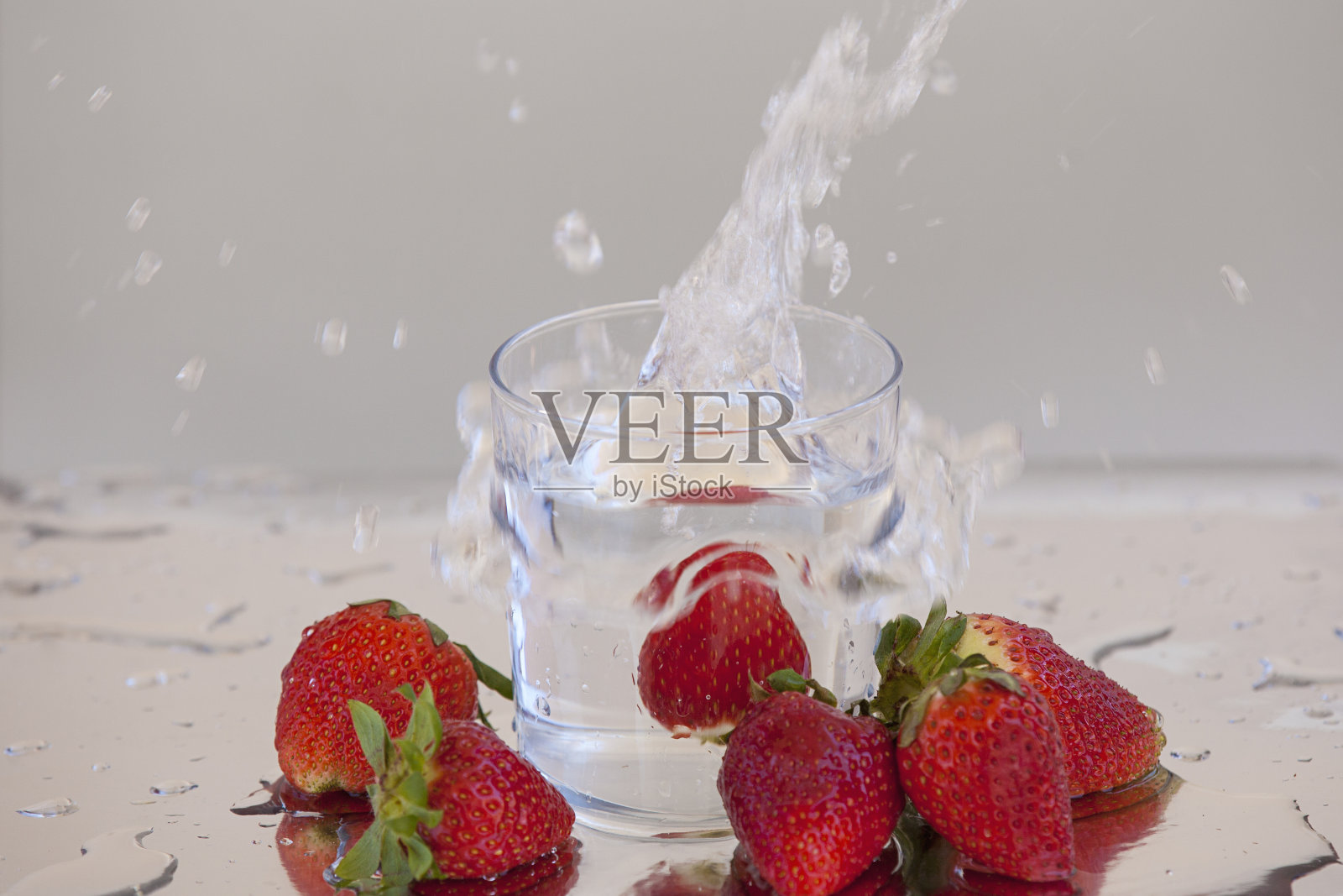 草莓掉进一杯水里照片摄影图片