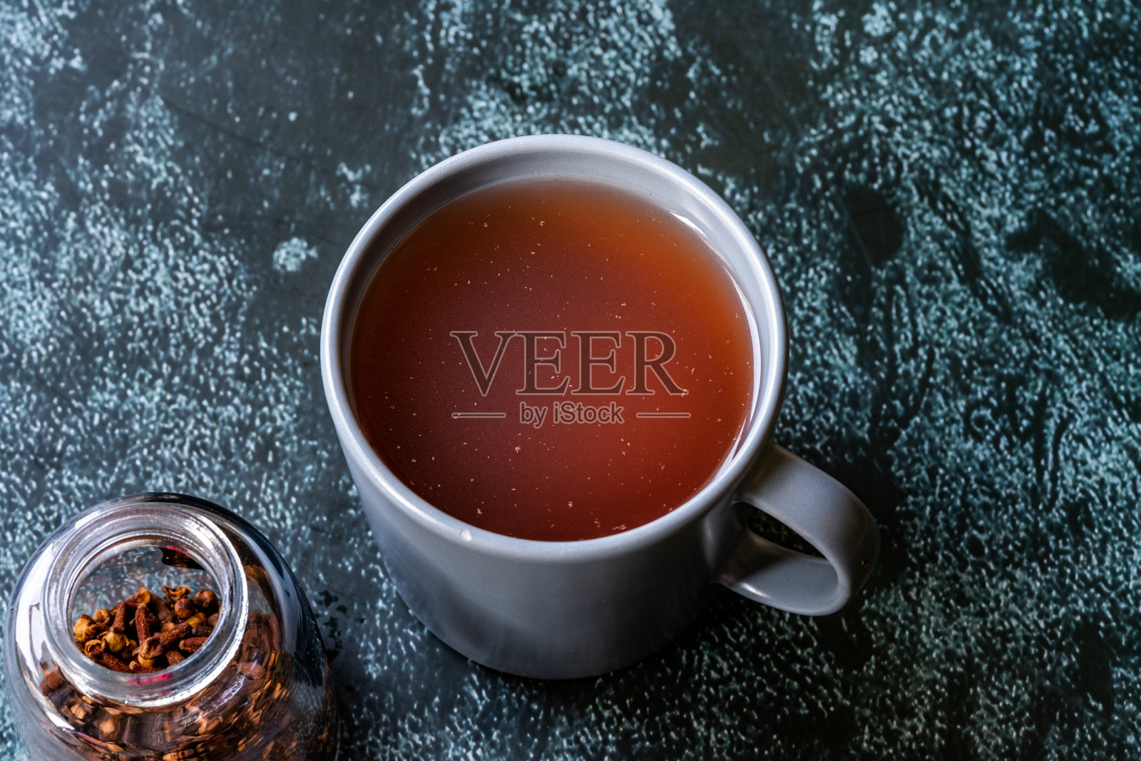 漆树水或茶和干燥的红色漆树香料与丁香在玻璃。照片摄影图片