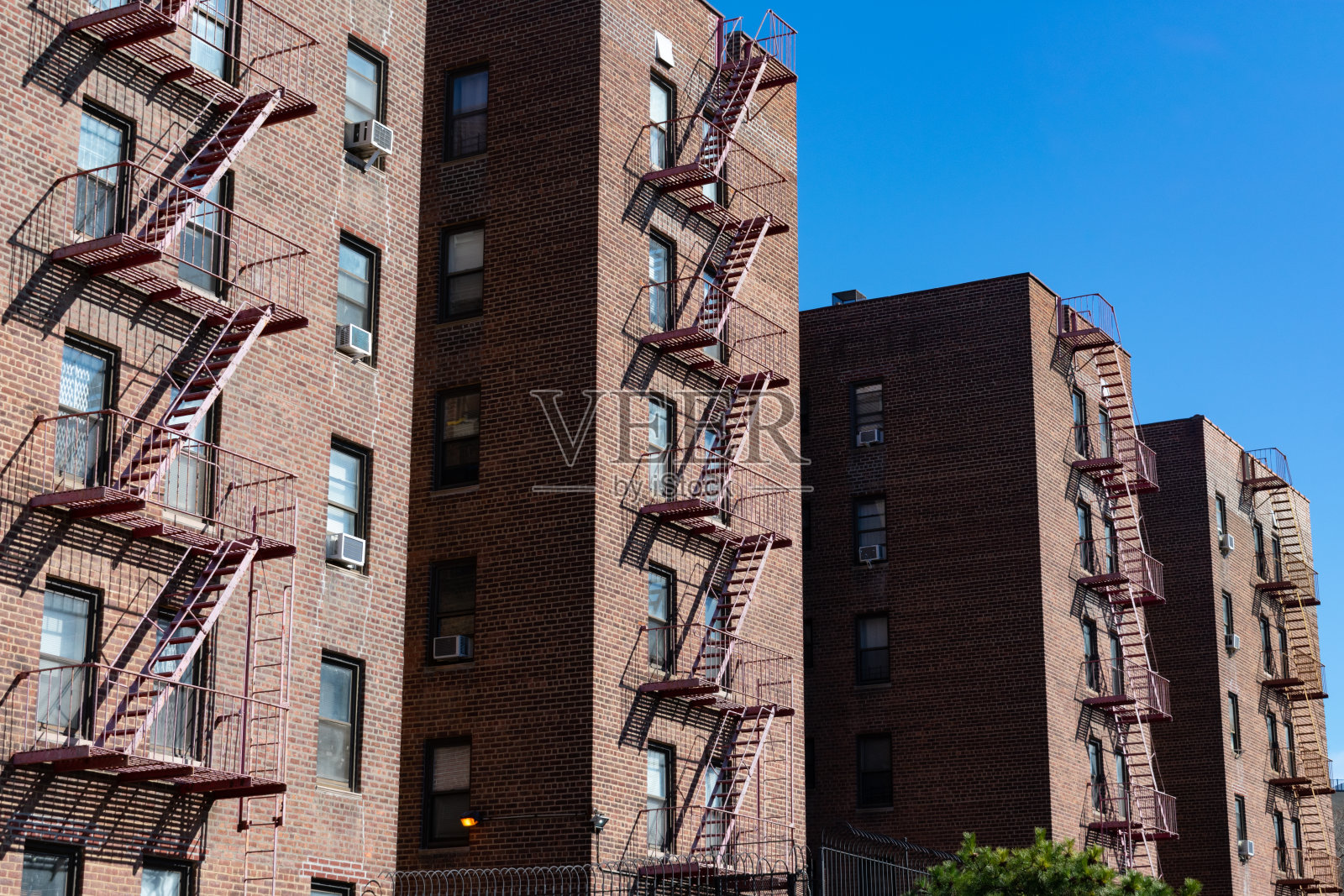 纽约市艾姆赫斯特皇后区的一排相同的基本旧砖砌住宅和防火梯照片摄影图片