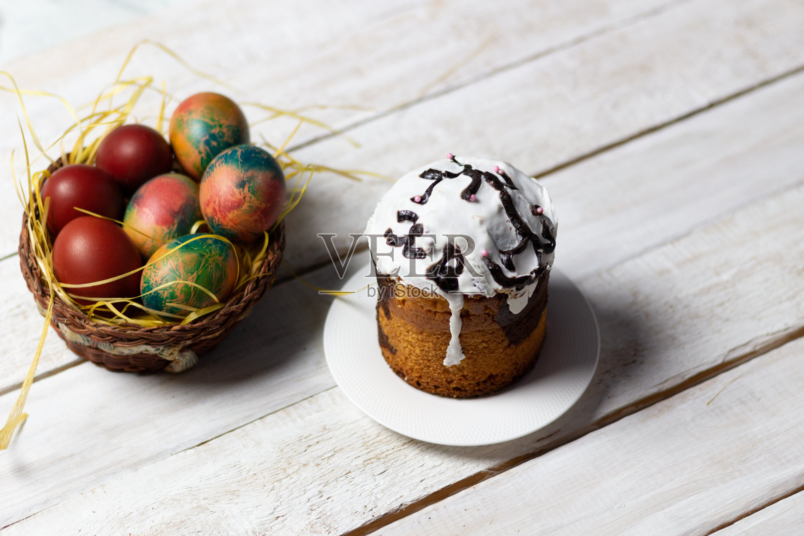 彩色的复活节彩蛋放在木桌上，上面放着蛋糕照片摄影图片