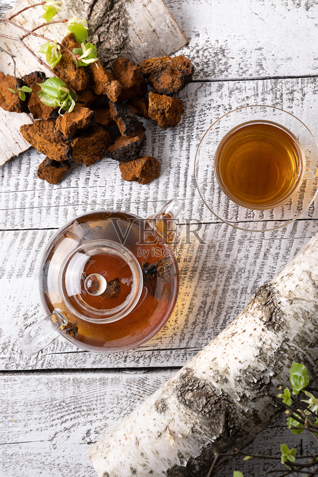 茶加蘑菇浸在玻璃茶壶在白板上。从以上观点。照片摄影图片