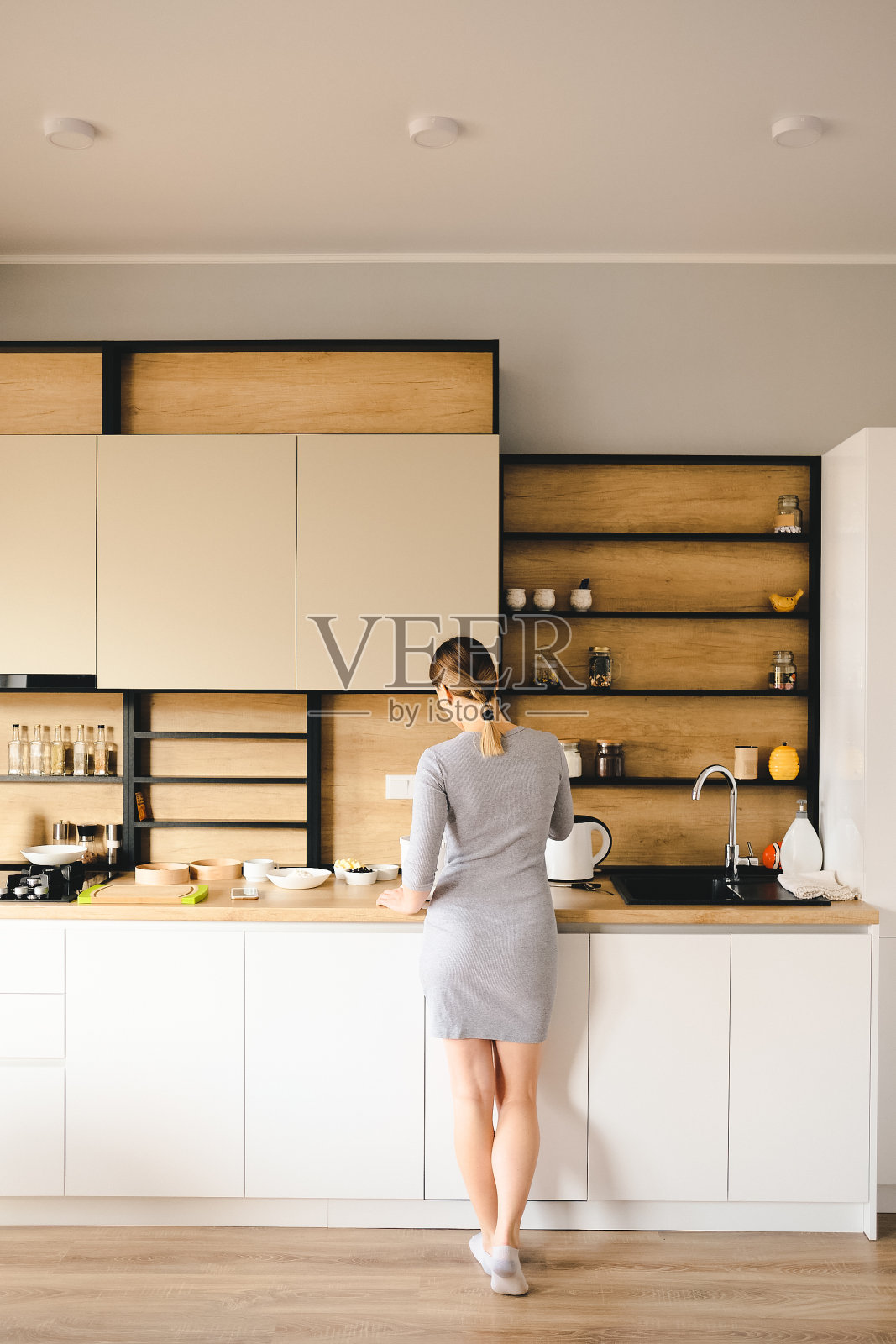 女人站在现代化厨房旁边的后视图照片摄影图片