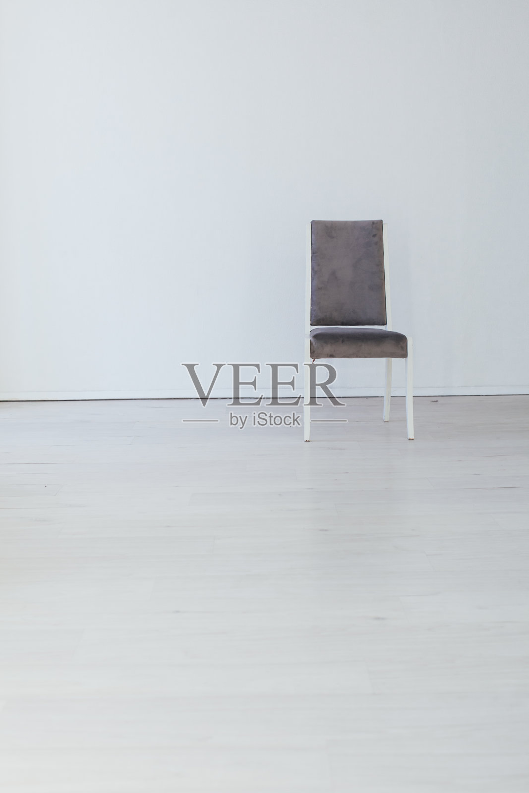 白色办公室的墙上有一把灰色的椅子照片摄影图片