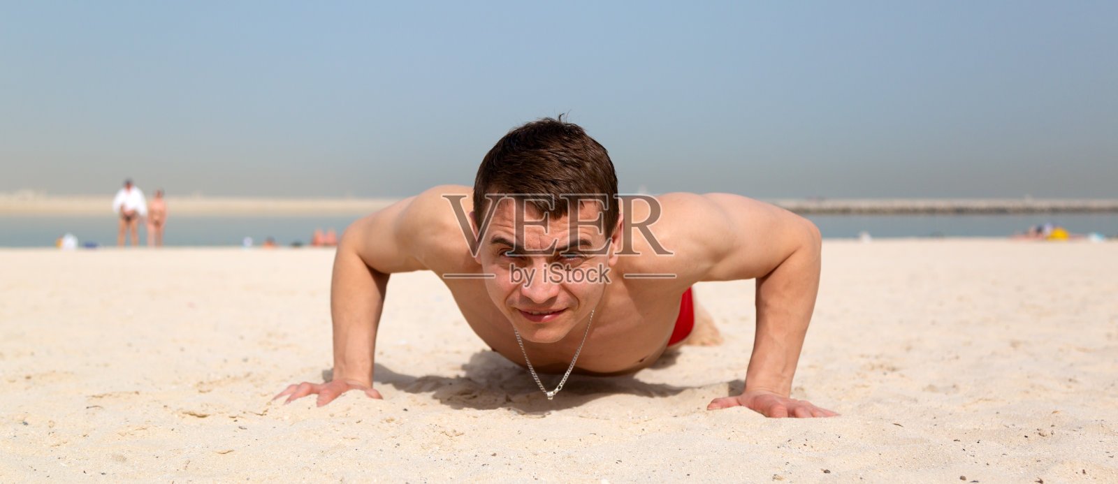 男子在城市海滩上做运动。照片摄影图片