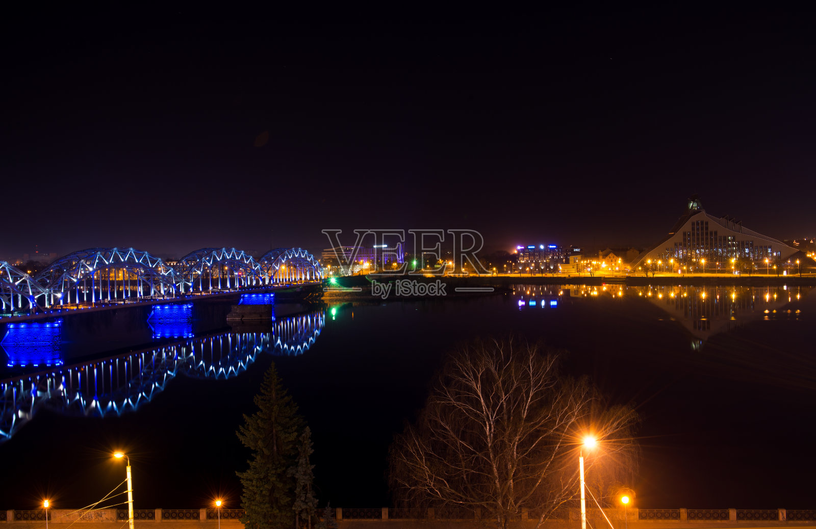 夜间在里加的铁路桥和建筑物照片摄影图片