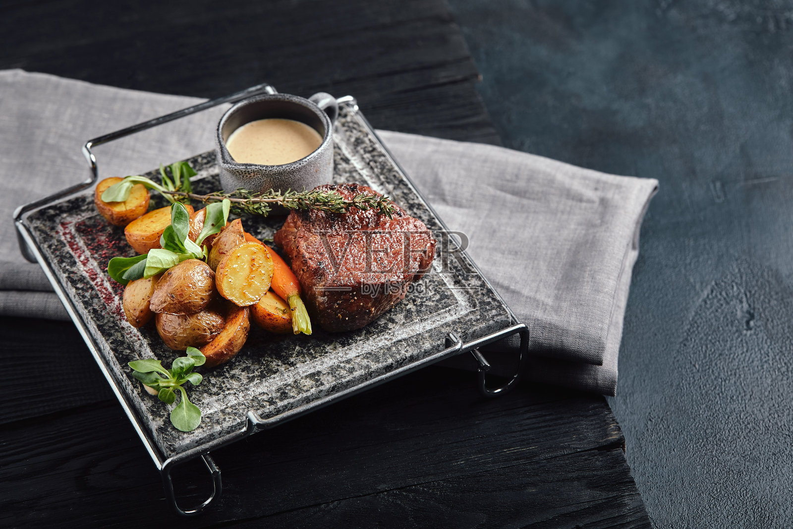 烤肋眼牛排在石烤架上在黑暗的背景照片摄影图片