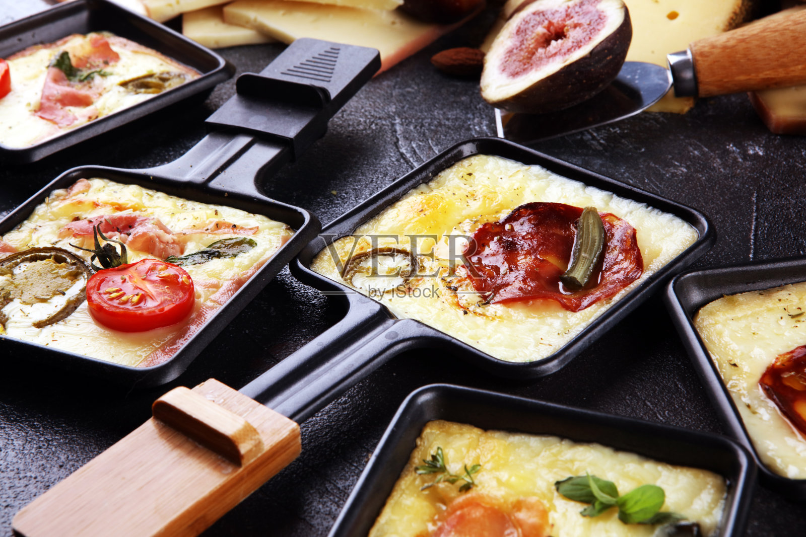 美味的传统瑞士融化raclette奶酪配煮或烤马铃薯丁。照片摄影图片