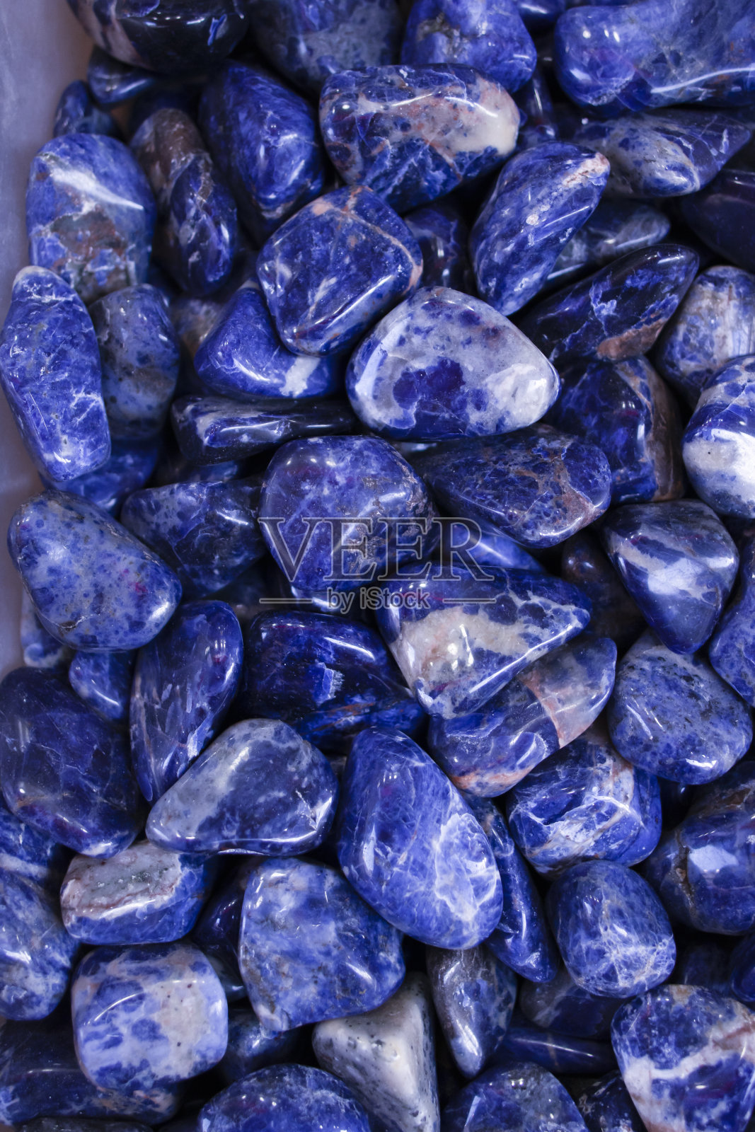 盒子里有不同的打磨过的蓝色天然石材。照片摄影图片