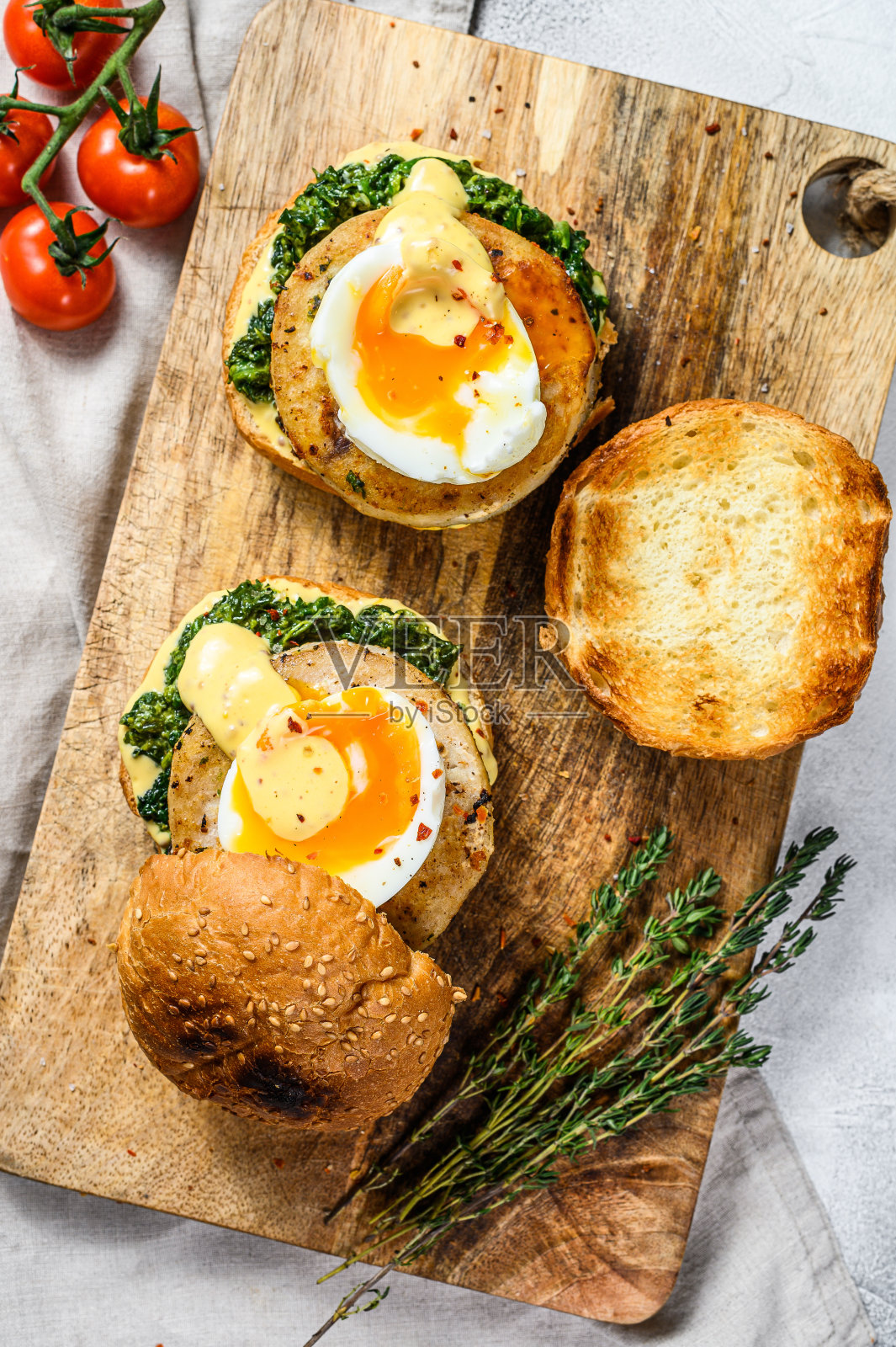 自制的鱼肉汉堡配鳕鱼片、鸡蛋和菠菜。灰色的背景。俯视图照片摄影图片