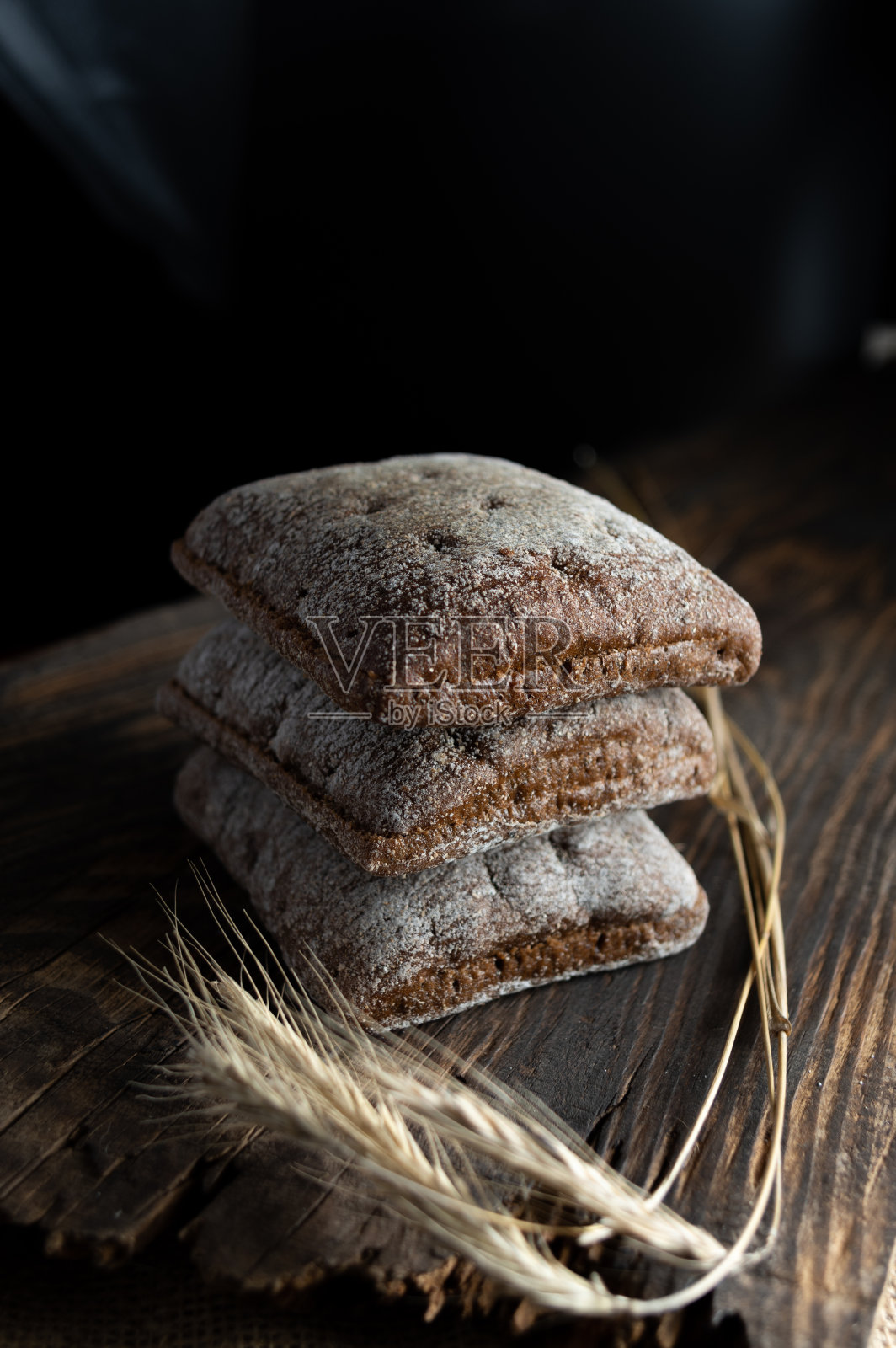 黑面包做三明治。汉堡包用的黑面包。面包和小麦的小穗。照片摄影图片