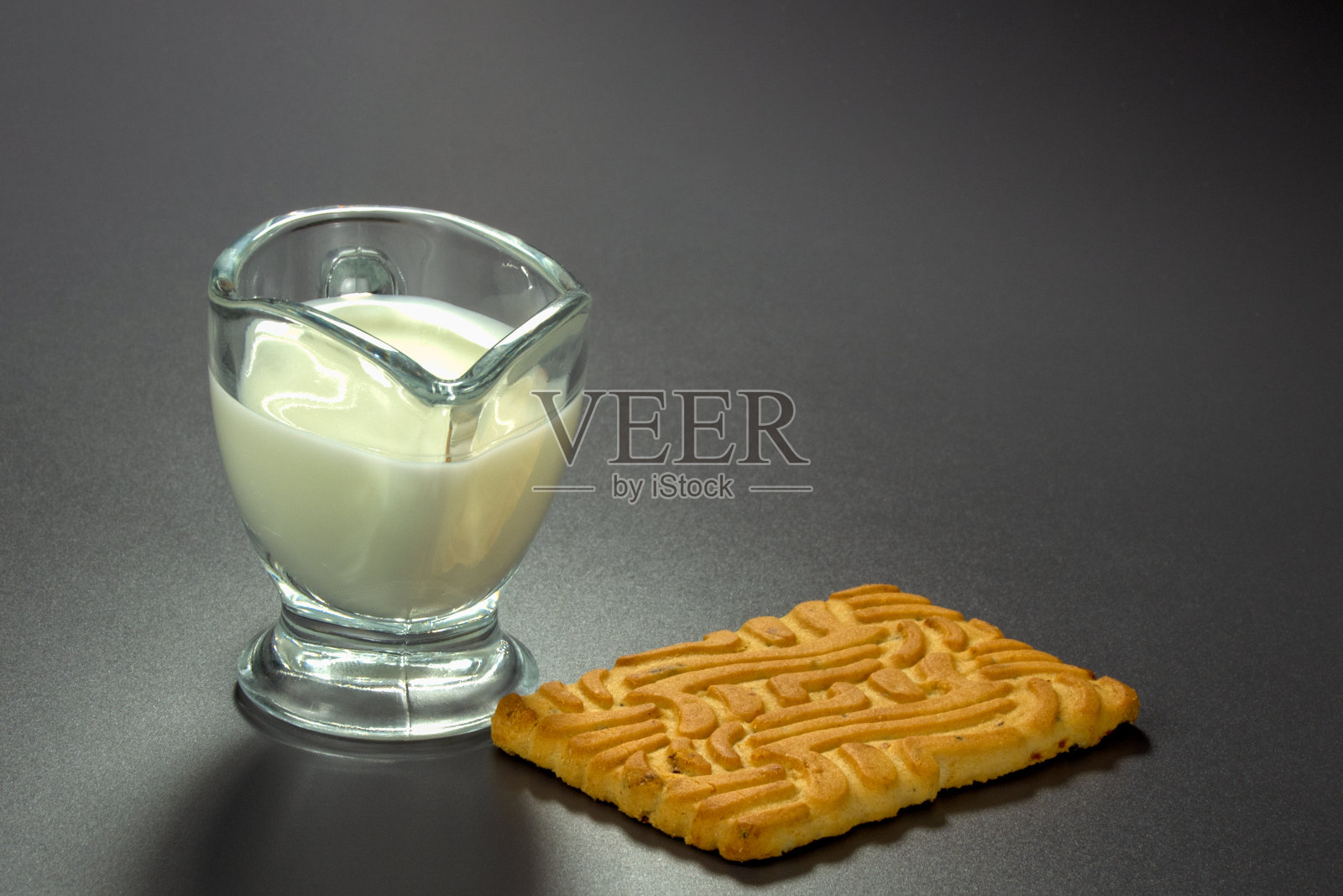 透明玻璃酱船与牛奶和饼干特写在灰色背景照片摄影图片