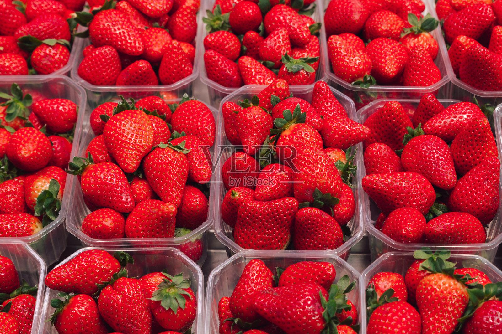 市场上摆满了美味草莓的托盘照片摄影图片
