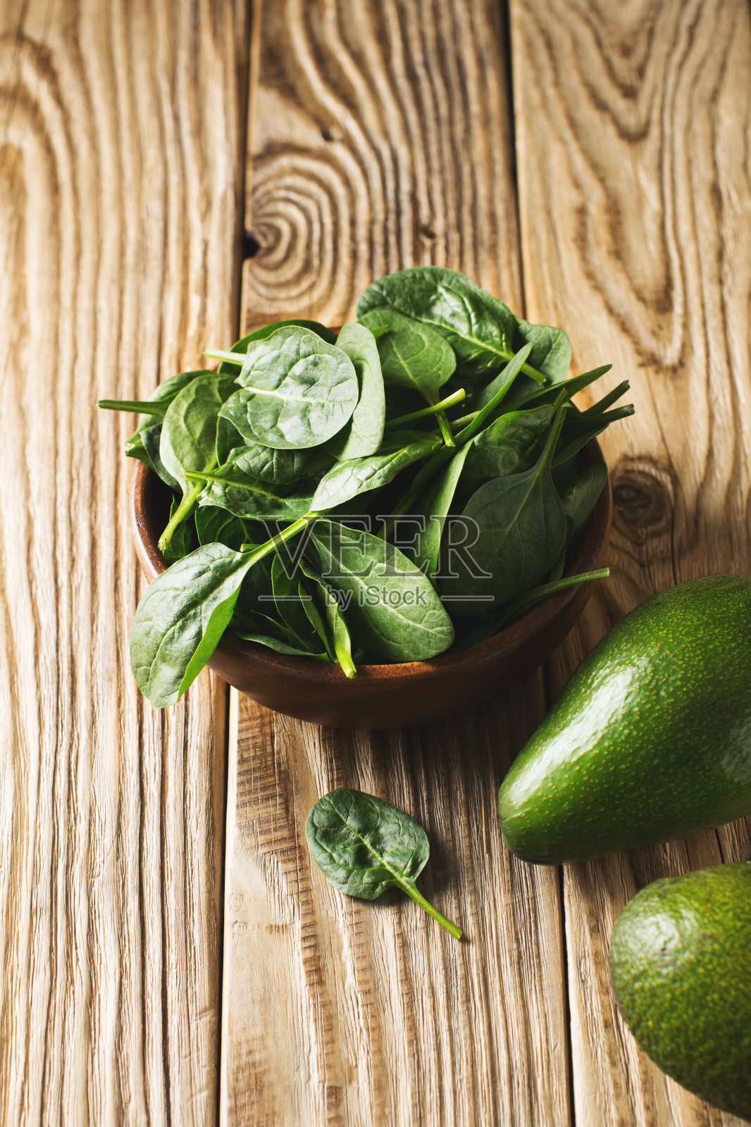幼菠菜和鳄梨放在木碗里，绿色健康的食材照片摄影图片