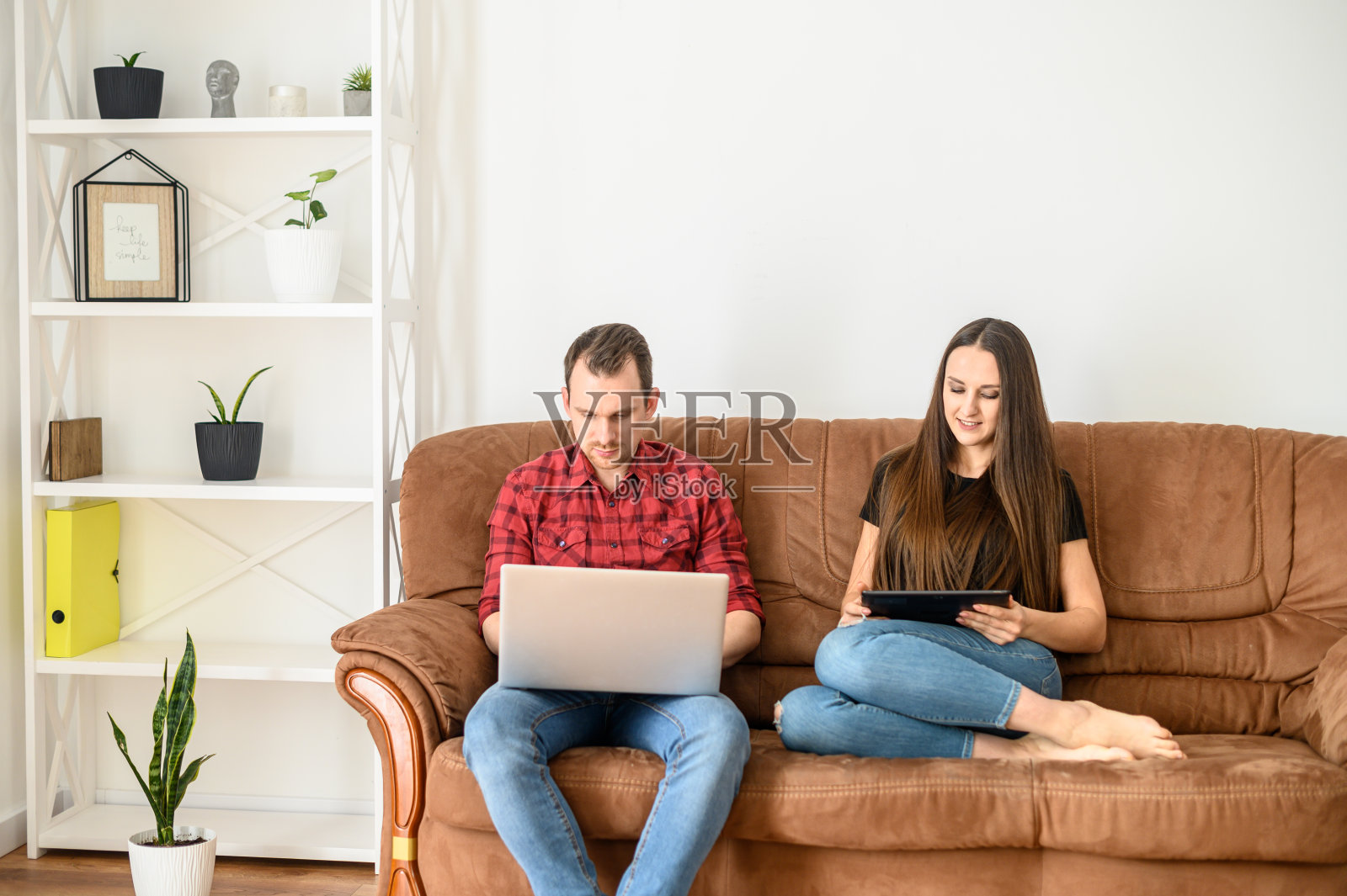 一对年轻夫妇坐在沙发上照片摄影图片