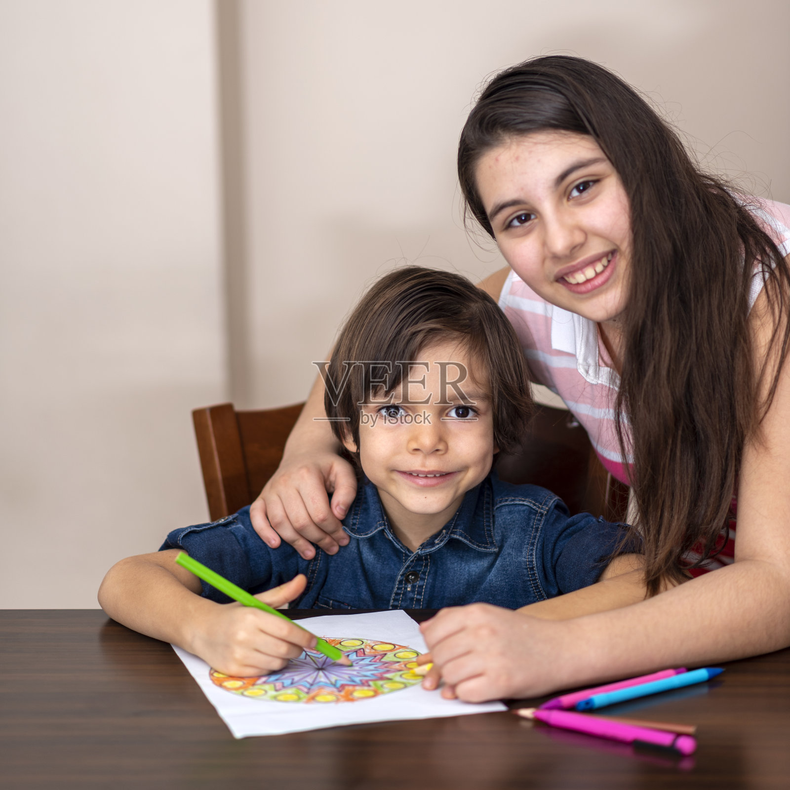 妹妹在家帮弟弟在纸上画画照片摄影图片