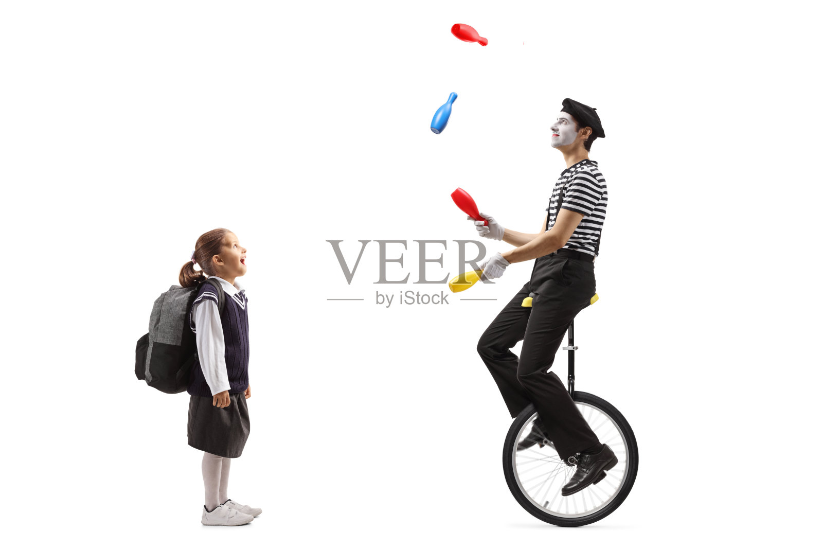 一个女学生在看小丑耍杂耍和骑独轮车照片摄影图片