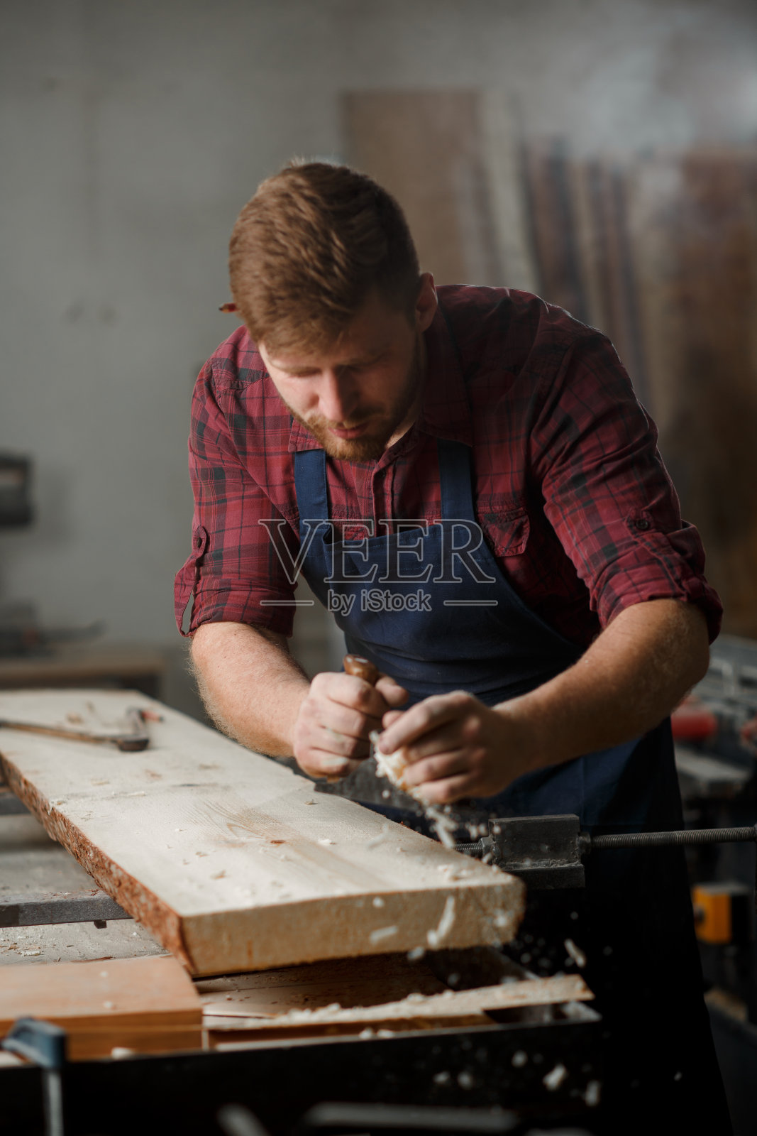 木匠师傅在车间里摆弄这棵树。小型企业照片摄影图片