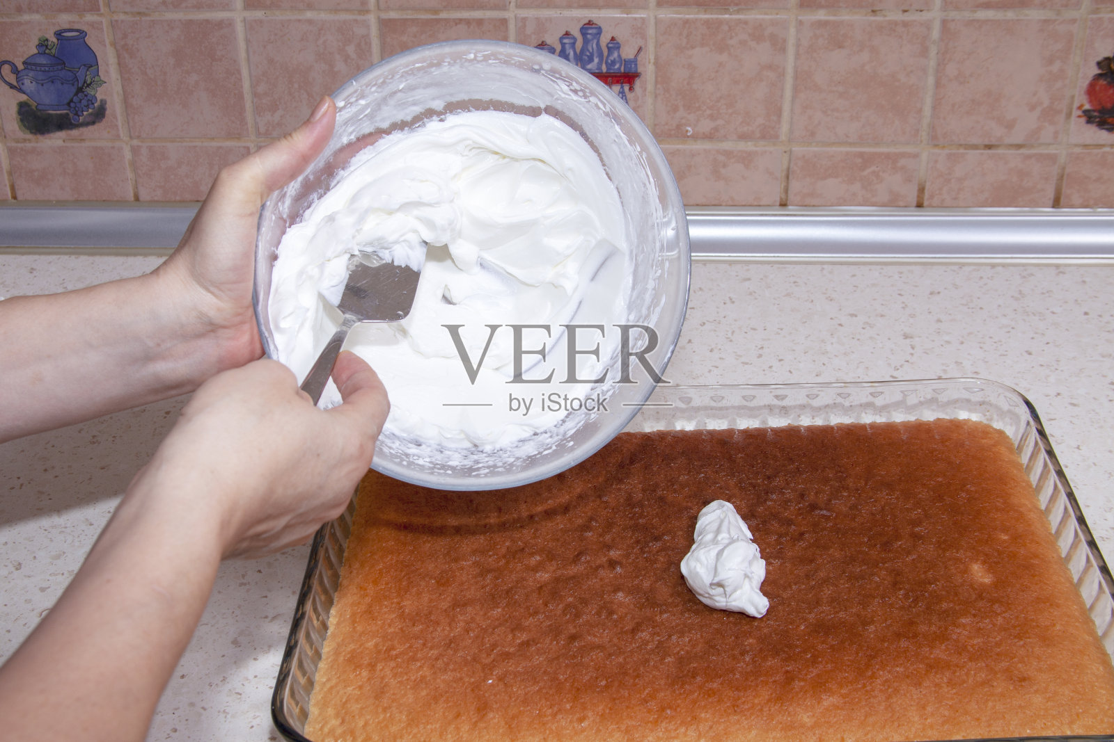 女人装饰美味的蛋糕-鲜奶油照片摄影图片