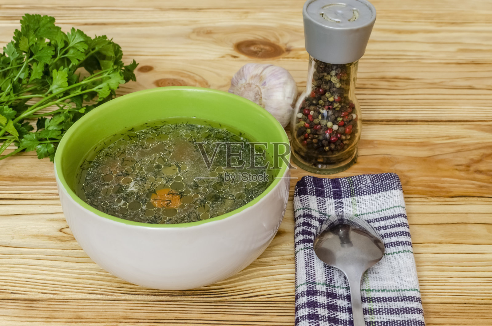 餐巾上碗里的鸡汤。照片摄影图片