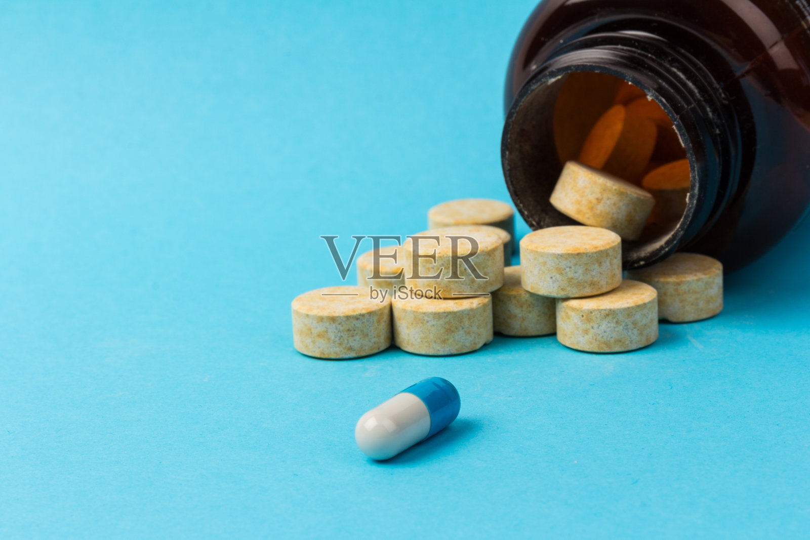 药片孤立在蓝色背景下。医疗药物胶囊。冠状病毒的概念照片摄影图片