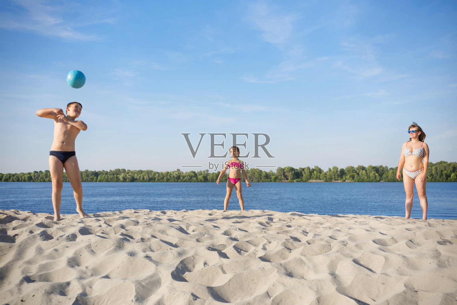 在河岸上进行家庭排球运动。概念-运动游戏。照片摄影图片