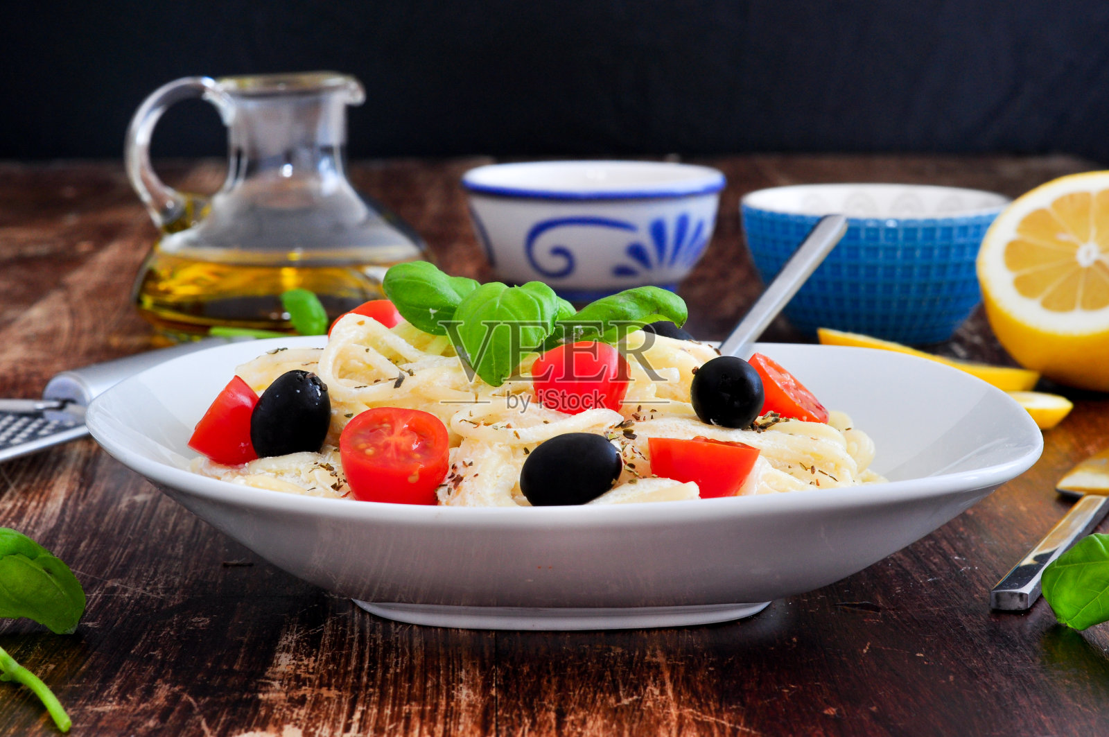 意大利面加奶酪、橄榄和罗勒照片摄影图片