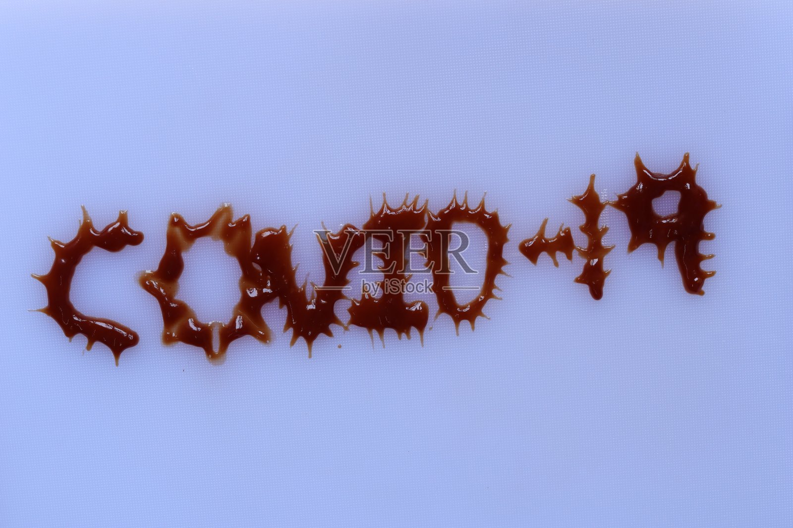 白色背景上刻有COVID-19字样的番茄酱照片摄影图片