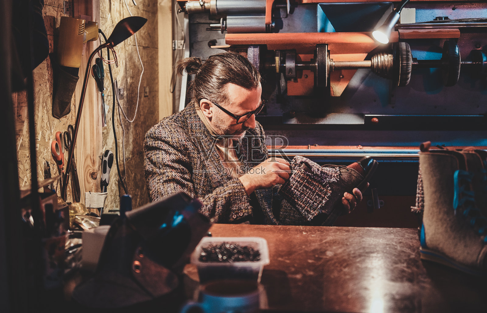 靴子制造商正在他的车间工作照片摄影图片