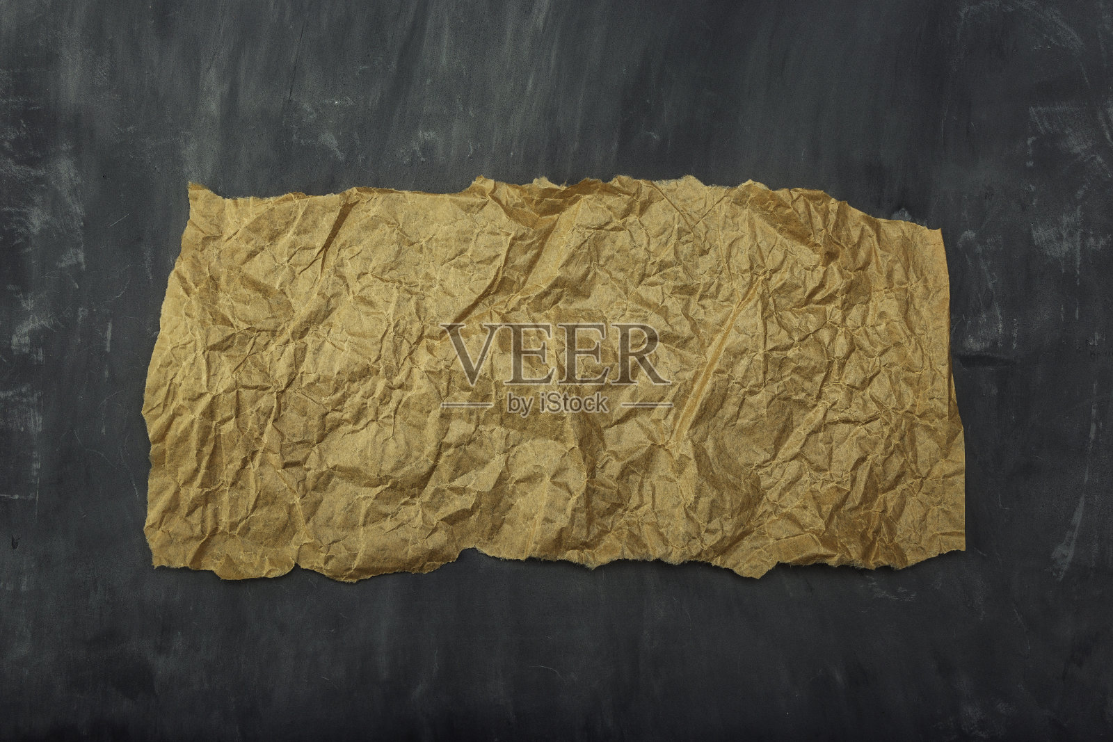 一张包装纸躺在灰色的水泥地上。背景。照片摄影图片