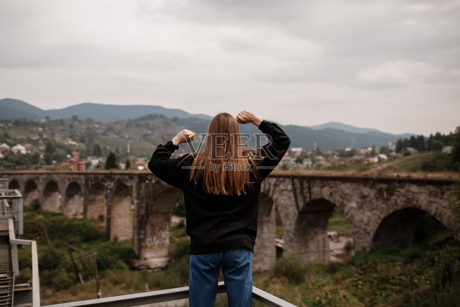 女游客喜欢旅游到乌克兰的历史名胜，高架桥在山区度假村沃罗赫塔，喀尔巴阡。旅行的概念。照片摄影图片