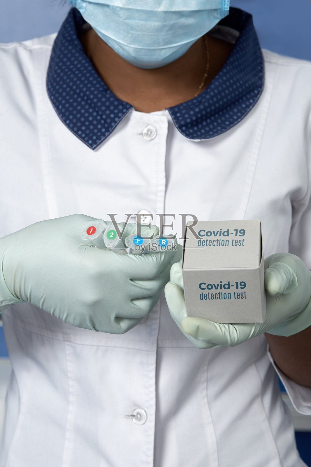 穿白色长袍和戴手套的医护人员或技术人员拿着试剂，用于诊断肺炎患者是否感染新冠病毒。用于检测新型冠状病毒的PCR核酸试剂盒、盒子和塑料试管照片摄影图片