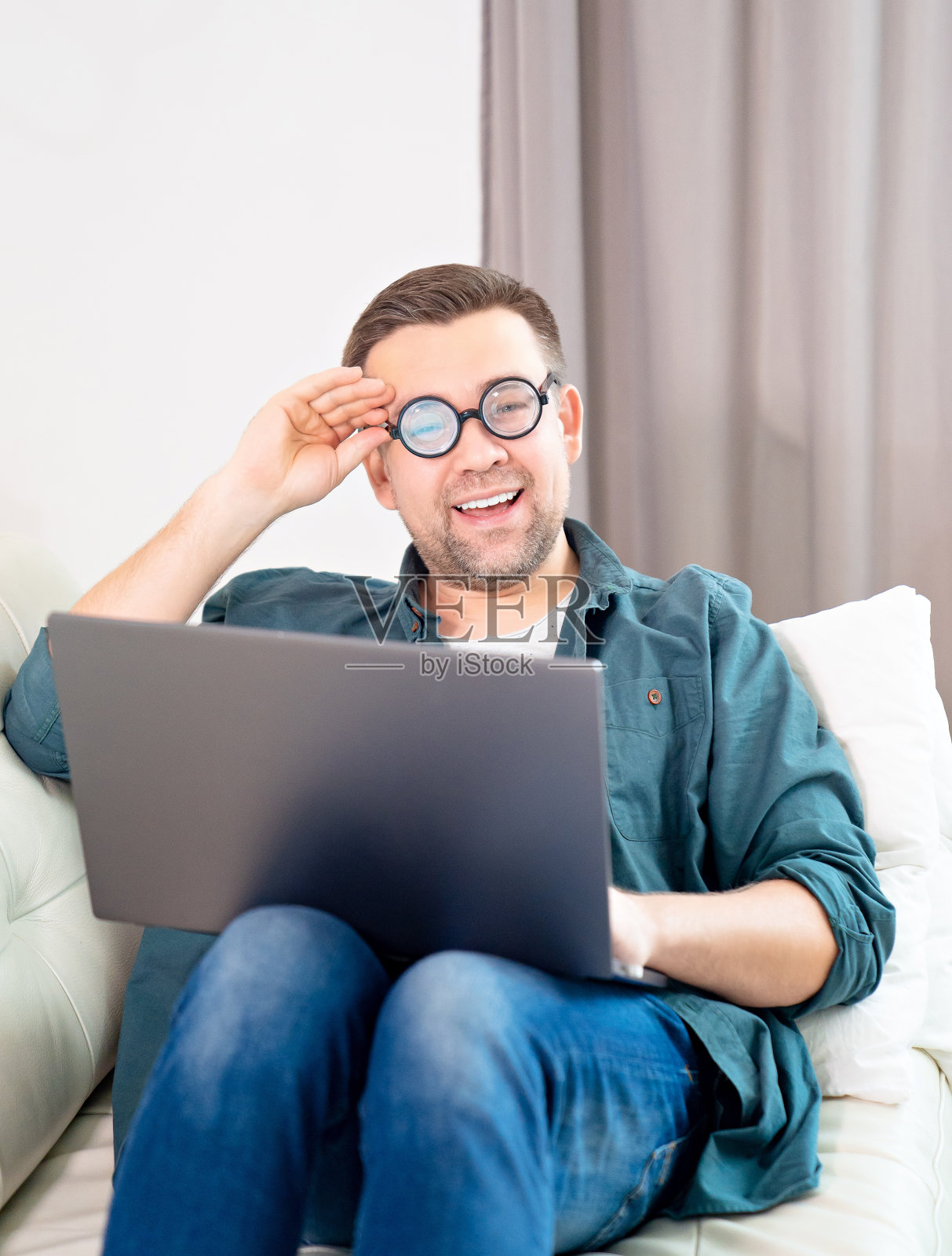 戴眼镜的男怪人在家上网工作。照片摄影图片