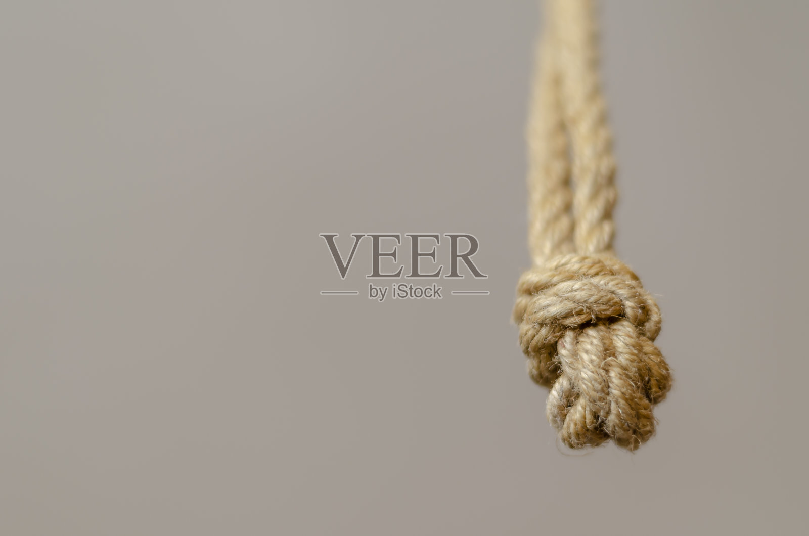 黄麻绳从上面垂下来，带结。照片摄影图片