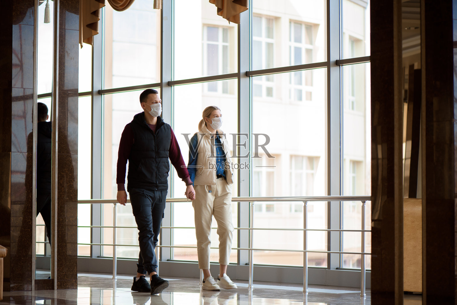 一男一女戴着防护面具在卡拉廷区。冠状病毒感染。照片摄影图片