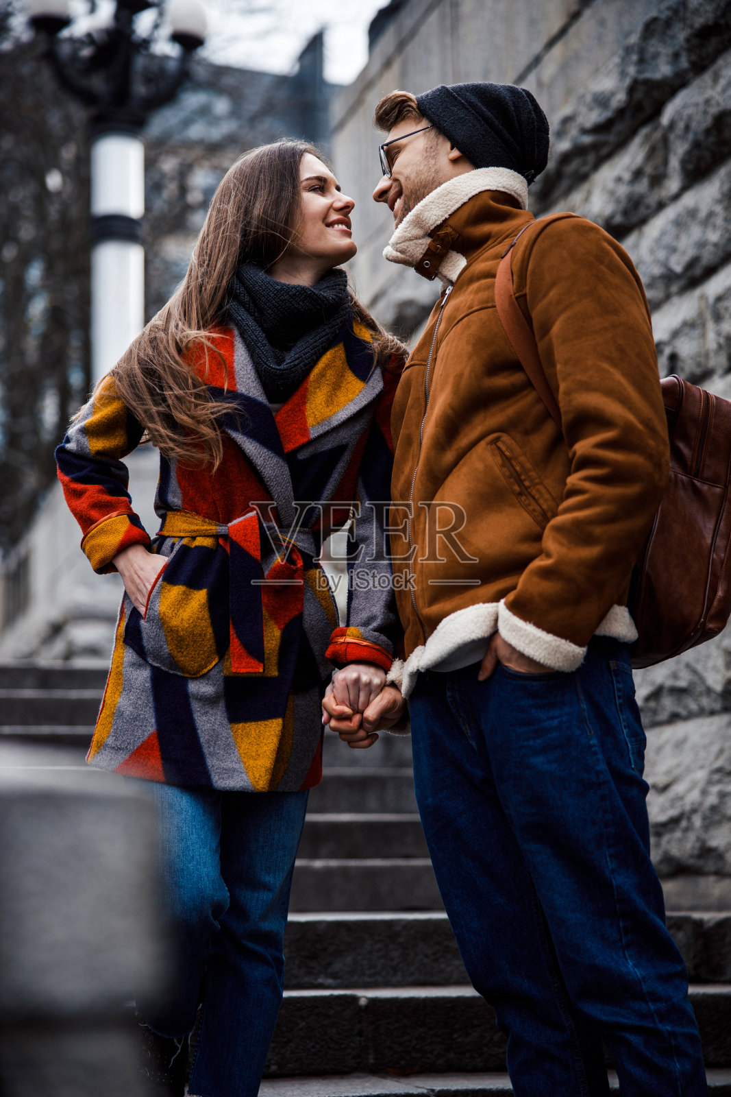 楼梯上一对可爱的情侣手牵着手，看起来很浪漫照片摄影图片